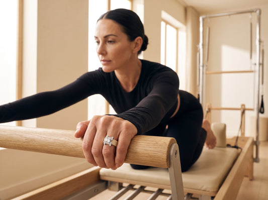 Woman on a Pilates reformer wearing the PANTHEON Flex Ring