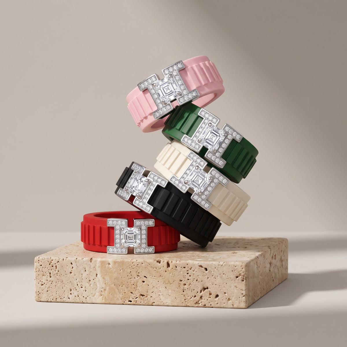 Five PANTHEON Flex Rings in different band colors stacked on travertine