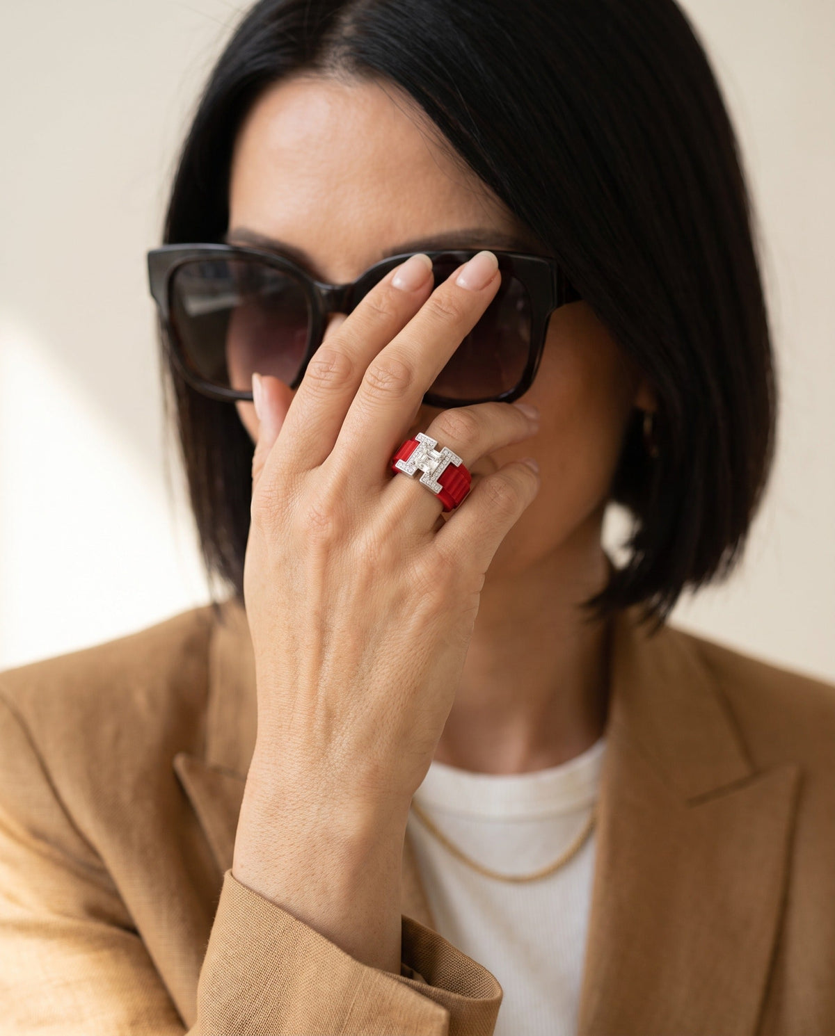 PANTHEON Flex Ring, Pompeii Red band, worn by a woman adjusting her sunglasses